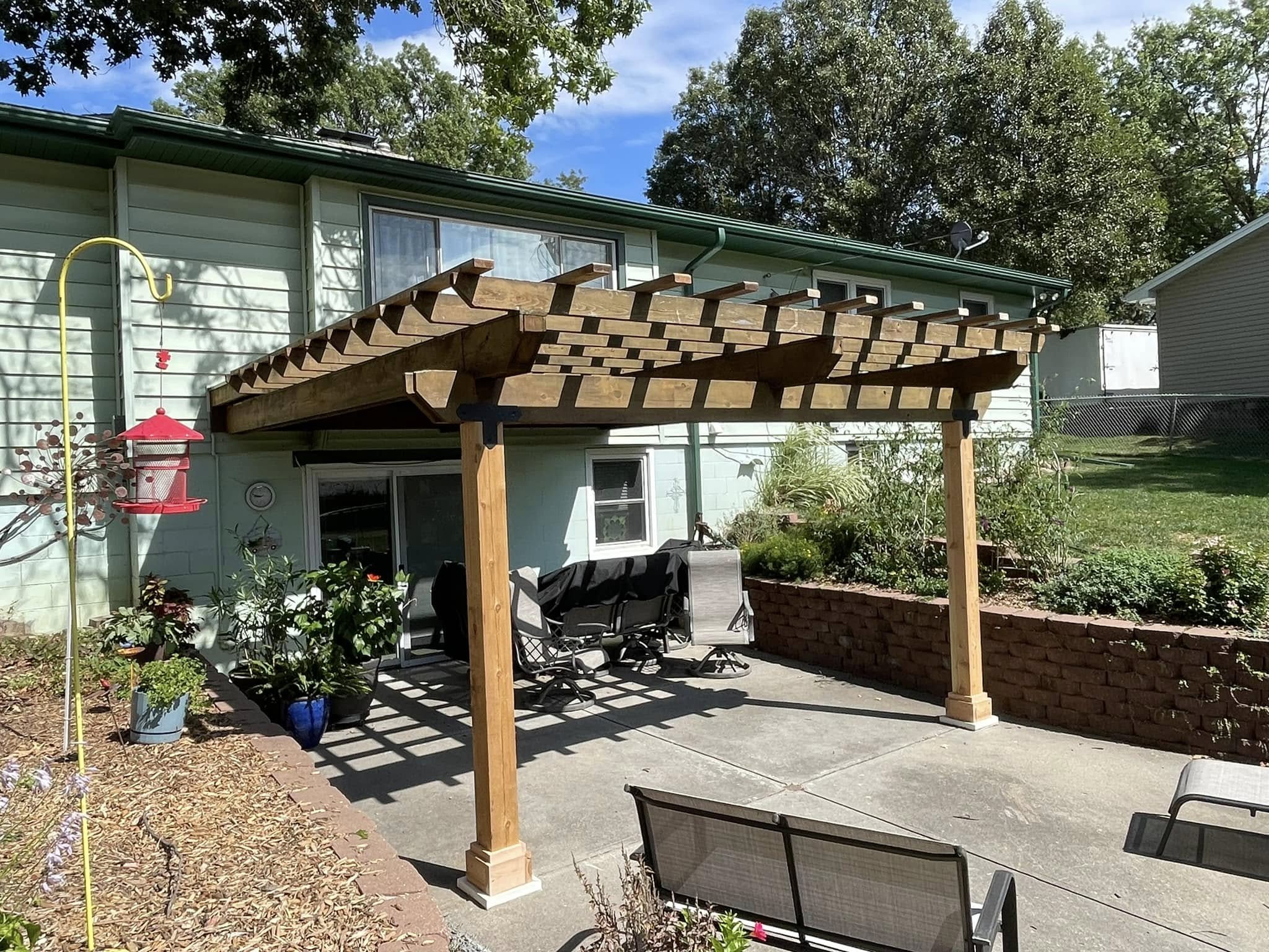 Cedar pergola canopy built over a backyard concrete patio